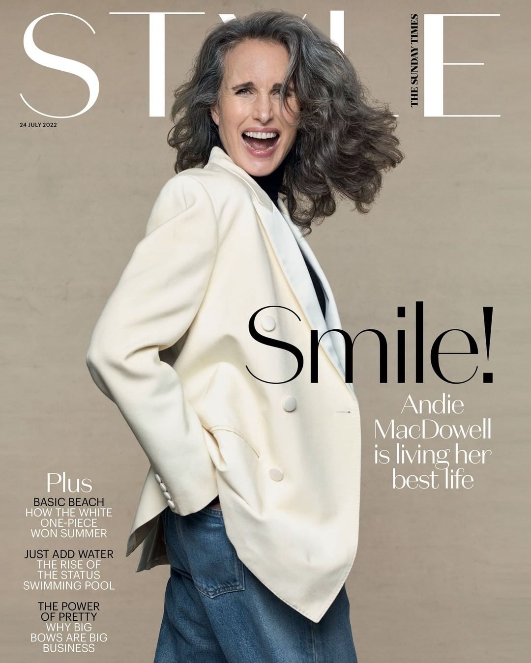 Andie MacDowell smiles on The Sunday Times Style cover, wearing a cream blazer and blue jeans against a neutral background.