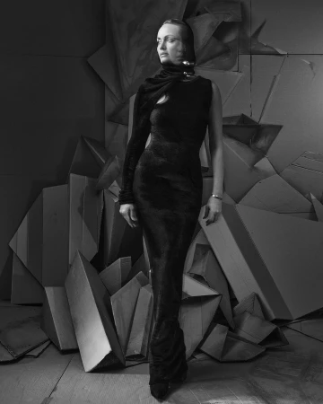 Elegant woman in black one-shoulder gown poses against geometric backdrop in black and white, showcasing fashion and fine art photography.
