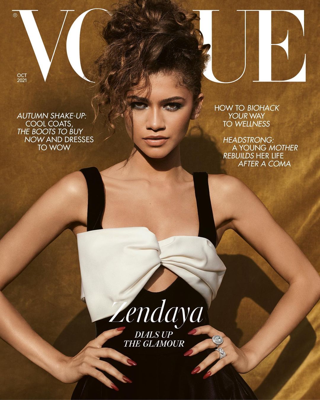 Zendaya on the cover of Vogue magazine, October 2021. She wears a black dress with a white bow, posing with hands on her hips against a gold backdrop.