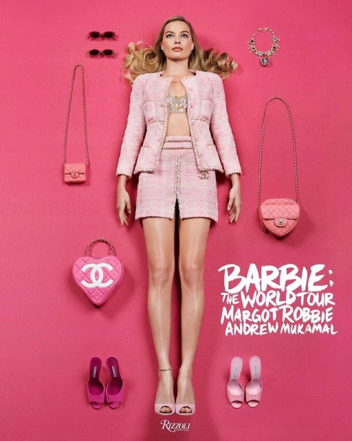 Fashion editorial featuring Margot Robbie wearing a pink Chanel skirt suit lying on a matching pink background, surrounded by accessories.