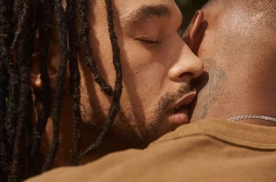 Close-up portrait of two men embracing warmly, shot in natural lighting by photographer Cully Wright.