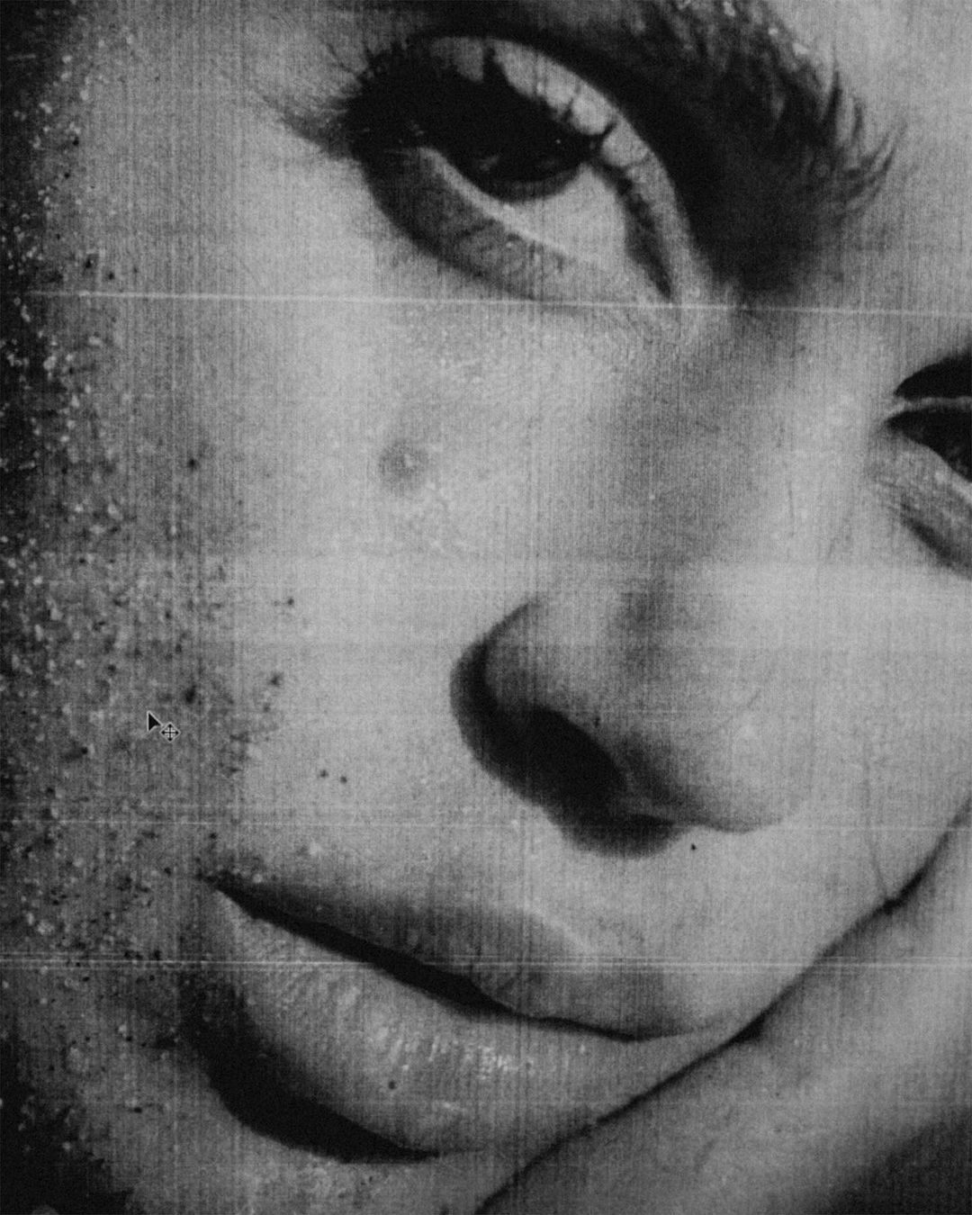 Monochromatic portrait of an adult female face with grains on skin, eye looking up, hand holding face, close-up shot, beauty concept.