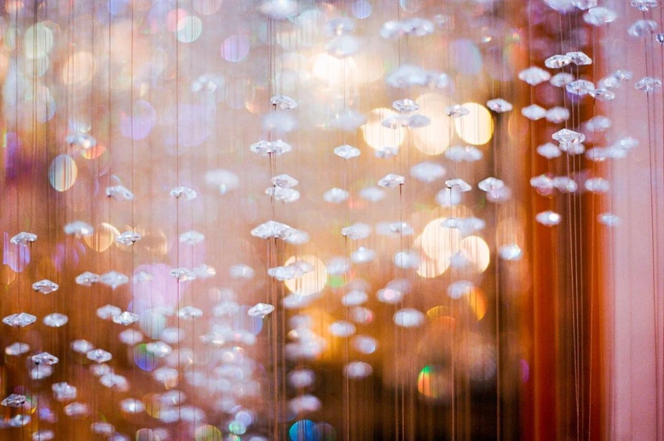 Sparkling diamond-like pendants hang from above, illuminated with a warm light, creating a luxurious and glamorous visual effect.