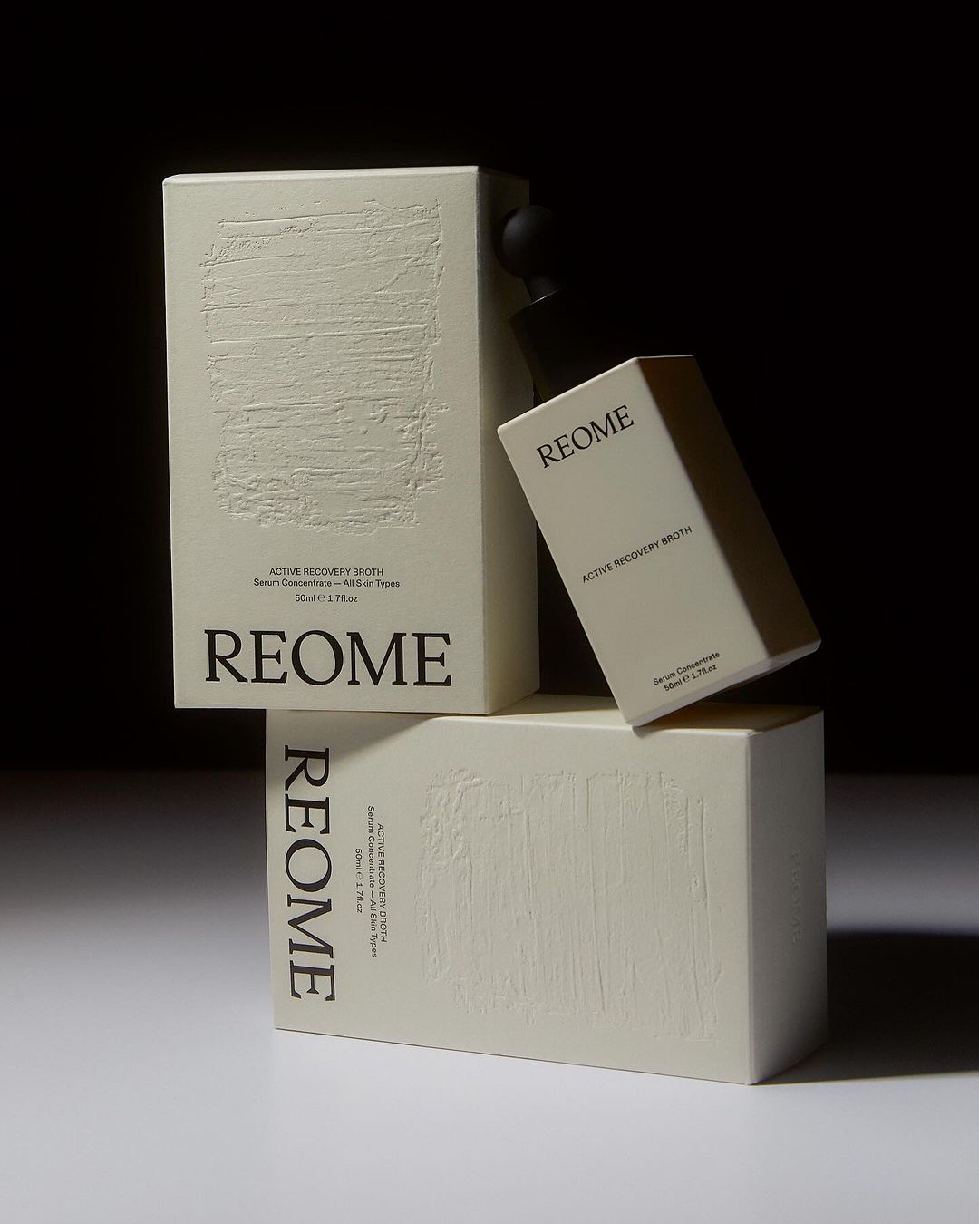 Aesthetic skincare product presentation featuring REOME Active Recovery Drops and Serum Concentrate in a minimalist composition with soft lighting.