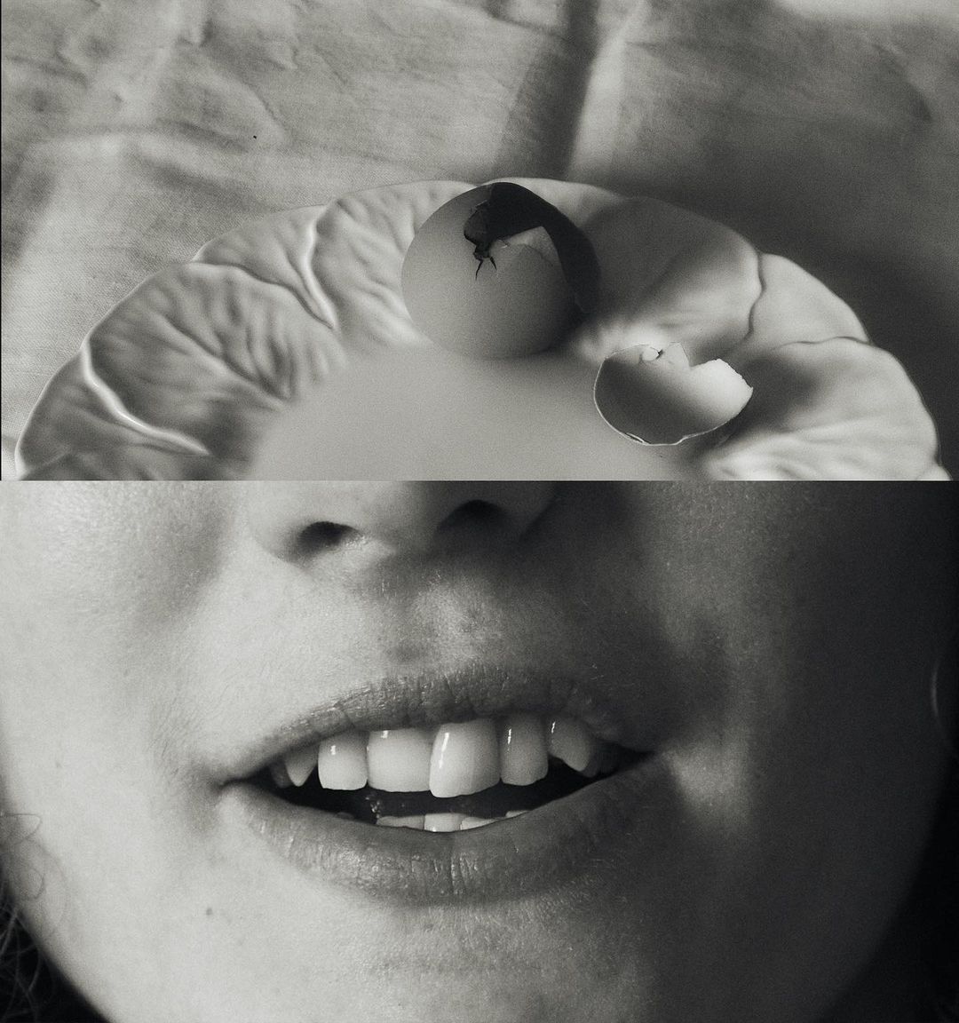 Surreal black and white composite image featuring an egg with a crack and an adult female's mouth with teeth showing.
