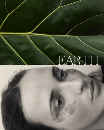 Close-up portrait of a woman with earthy markings on her face beneath a large green leaf with visible veins.