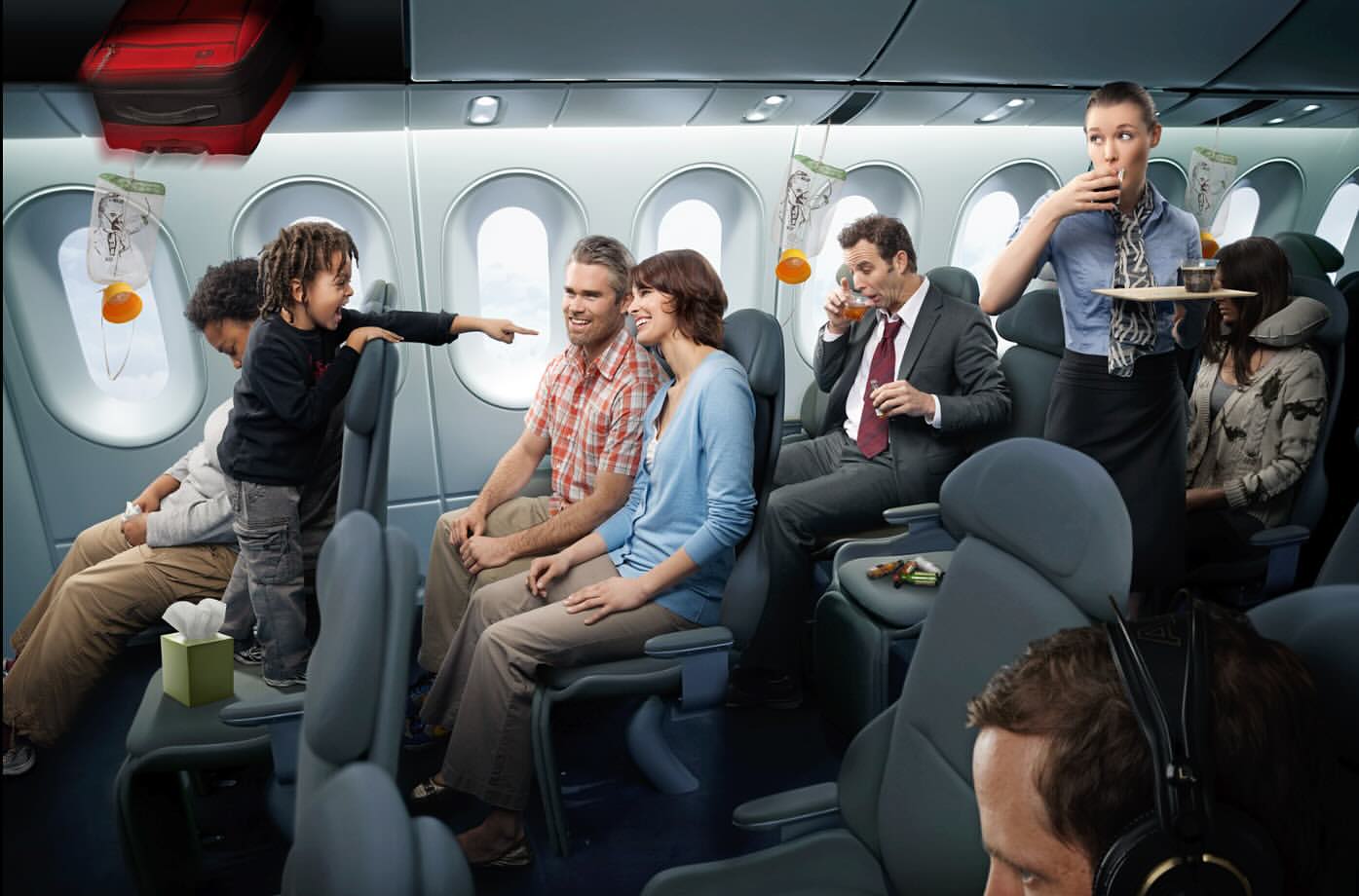 Airplane interior with passengers: a child standing on a seat, flight attendant serving, and luggage stowed overhead in a commercial airliner.