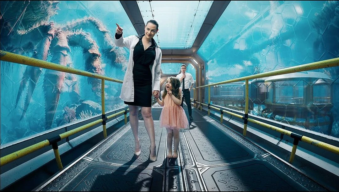 Woman and child walk in futuristic aquarium tunnel, man follows. A massive crab is visible through the glass wall of the tunnel.