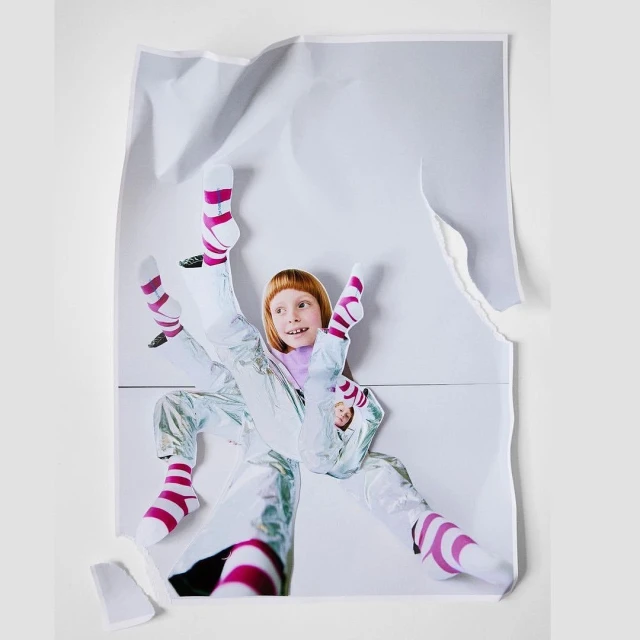 Collage of a girl in a silvery jumpsuit and striped socks on a torn white paper background, playful and creative imagery.