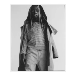 Child wearing striped long-sleeve shirt and hooded jacket against plain studio background by Damian Weilers.