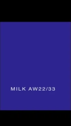 Solid royal blue background featuring the white typographic text MILK AW22/33 centered near the bottom.