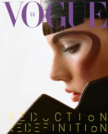 Close-up profile of a woman with avant-garde makeup and structured dark collar against a white background