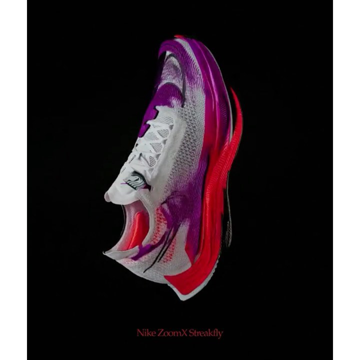 Nike ZoomX Streakfly shoe displays its sleek design with white laces, a purple and red midsole, and a black background, product-focused.