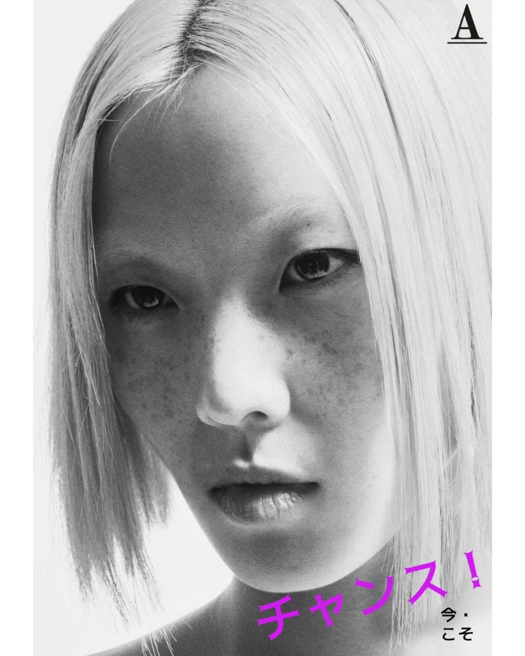 Close up portrait of a blonde woman with freckles and bleached eyebrows against a white background by photographer Dan Jackson.