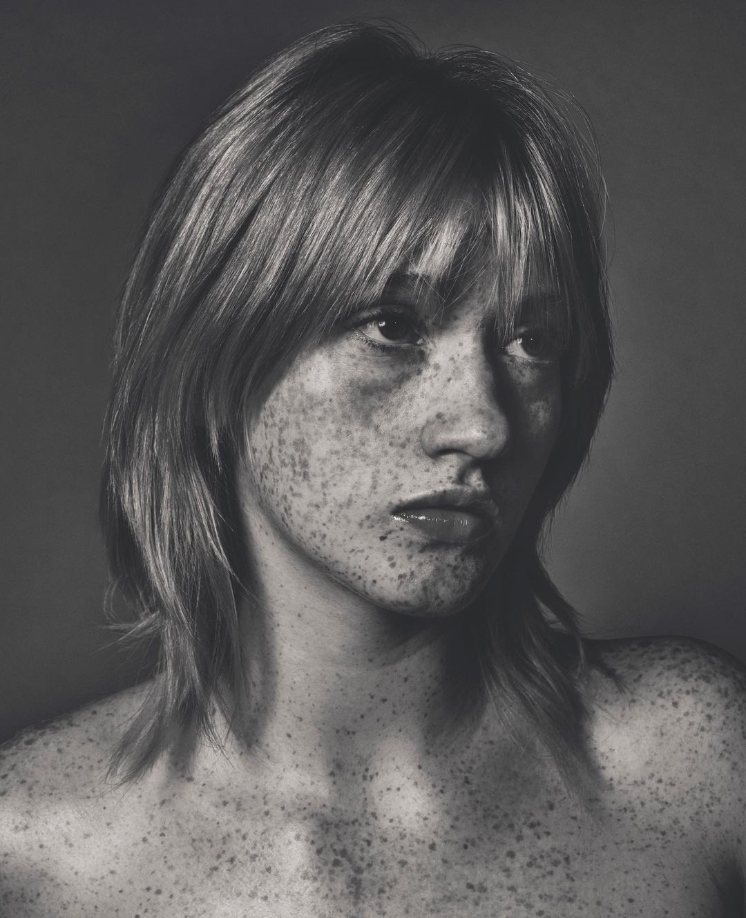 Portrait of a young woman with heavy freckles across her face and shoulders, medium shag haircut, shot by Dan Jackson
