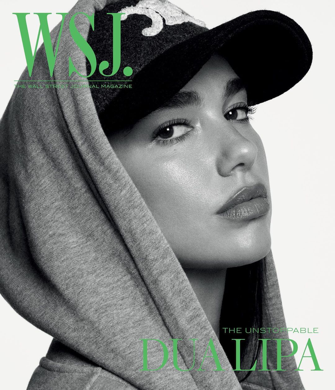 Close-up studio portrait of a young adult female model wearing a hooded sweatshirt and baseball cap, with WSJ magazine logo.