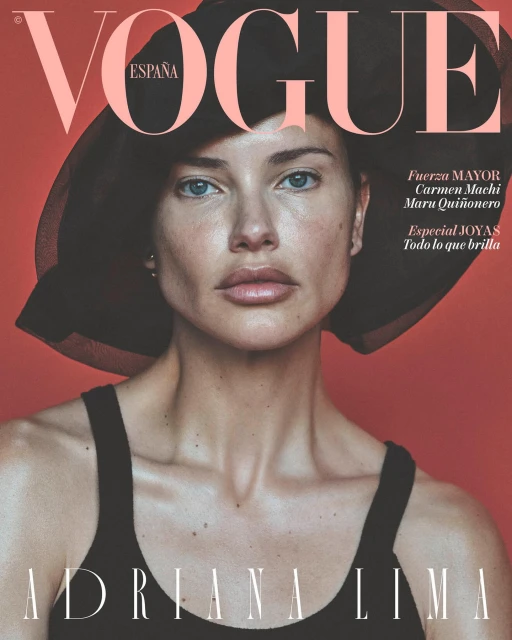 Fashion magazine cover featuring Adriana Lima wearing a black hat and tank top against a red backdrop, with 'Vogue España' at the top.