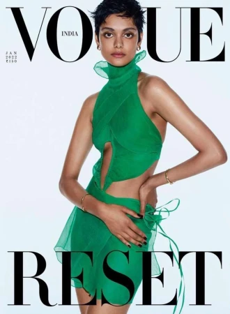 A woman with short dark hair wearing a vibrant green cutout dress against a clean white background, photographed by Dan Jackson.