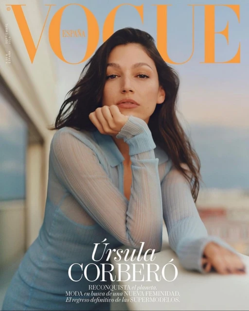 Ursula Corbero on a Vogue Espana cover. She is a light-skinned woman wearing a blue top. The background is a muted sunset color.