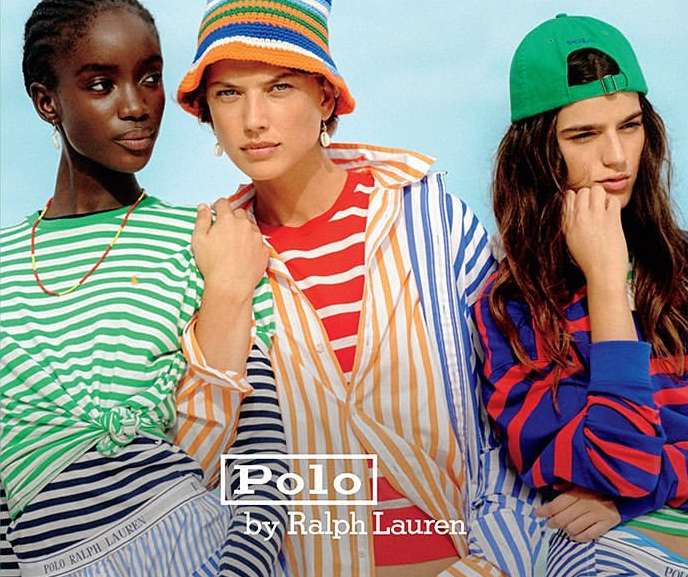 Three diverse fashion models wear striped shirts and headwear for Polo Ralph Lauren campaign against a bright cyan backdrop in a studio shot.