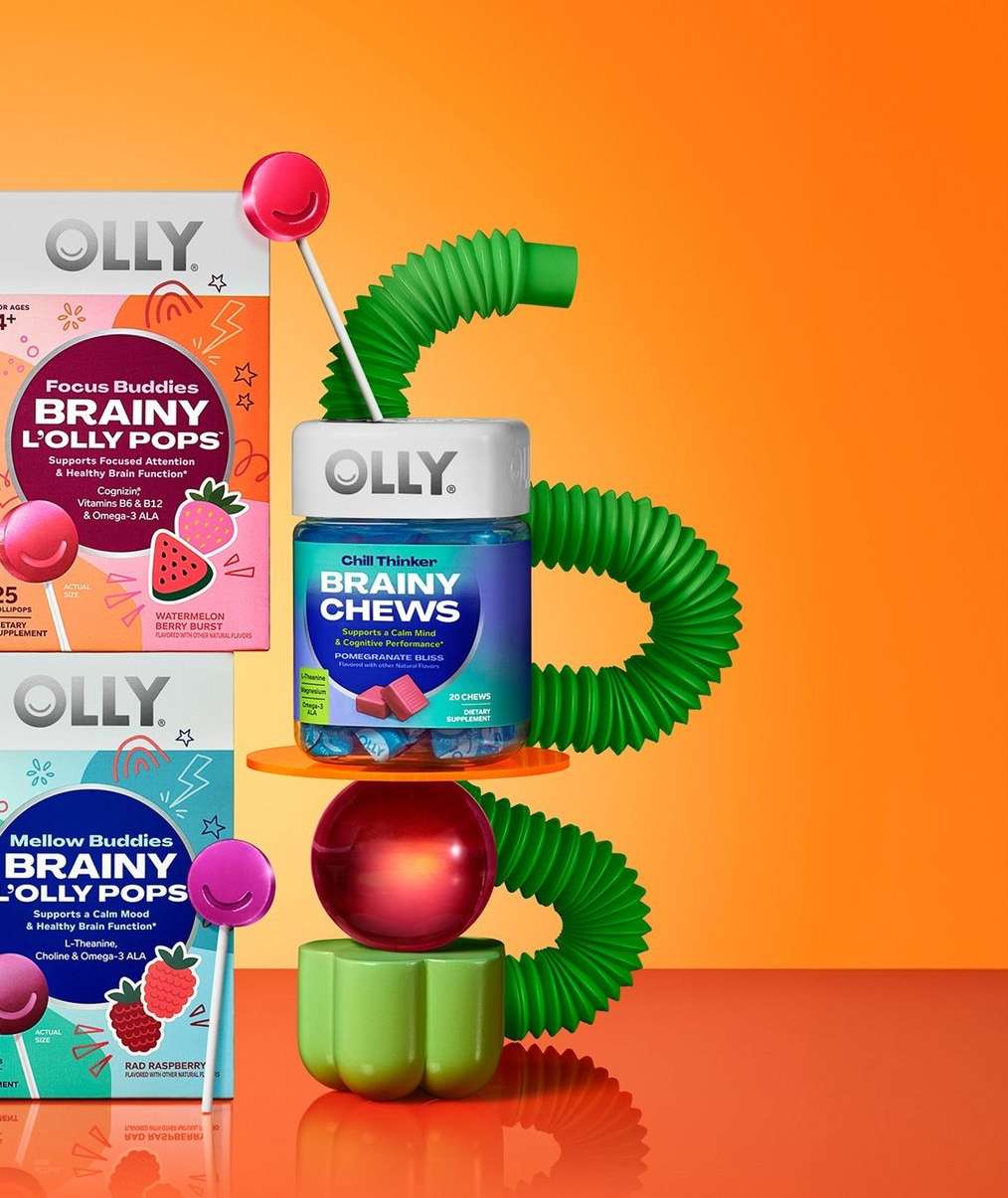 Still life of Olly Focus Buddies & Mellow Buddies Brainy L'Olly Pops and Olly Chill Thinker Brainy Chews against orange background.
