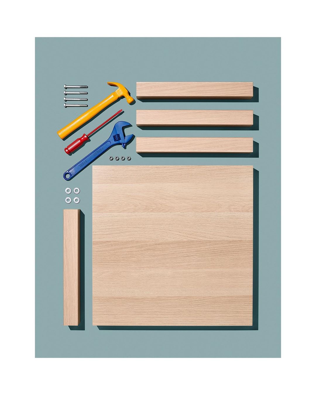 Elevated view of wood planks, screws, washers, hammer, wrench, and screwdriver on a blue background, staged for construction and assembly.