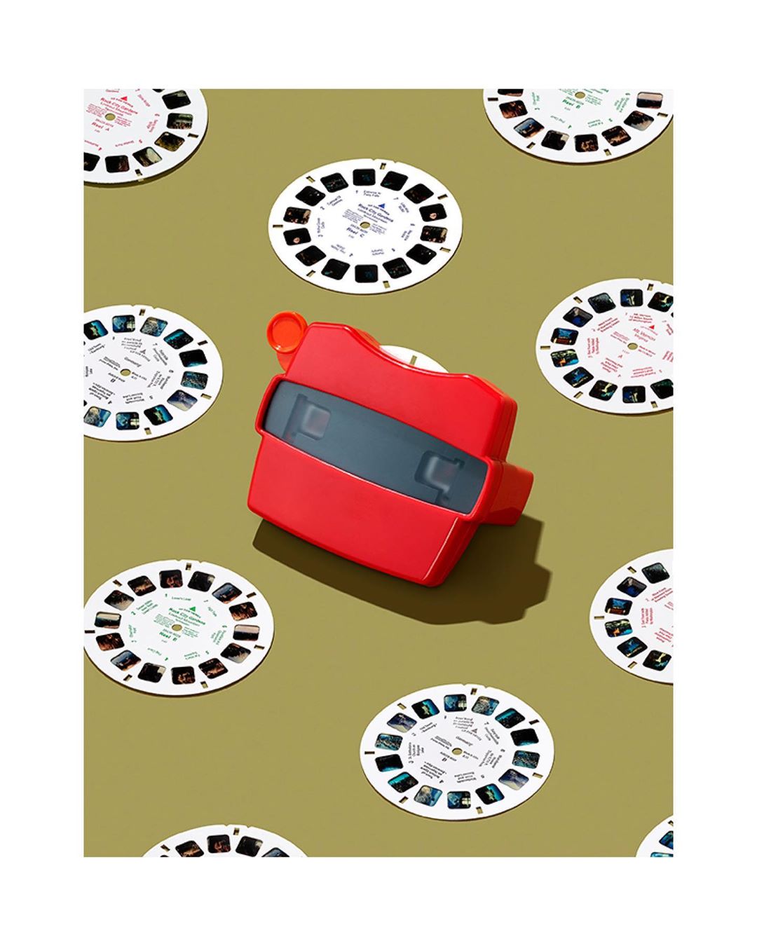 View-Master with reels on a khaki background. Nostalgic toy and retro entertainment concept. The focus is on the viewer.