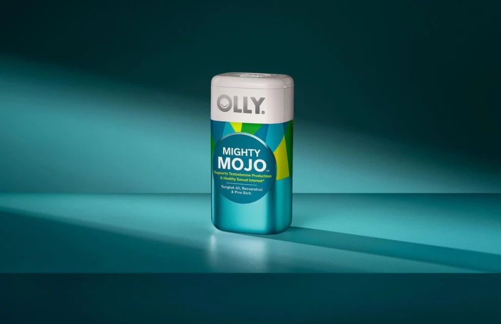 Olly Mighty Mojo supplement bottle on a blue surface with a blue background and lighting, product shot.