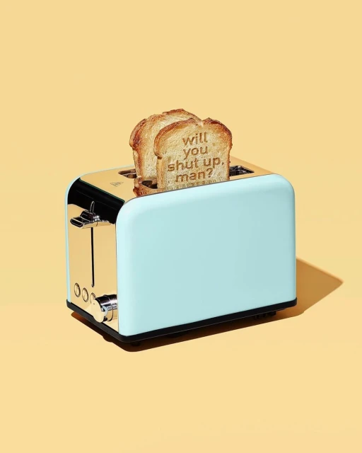 Toaster with slices of toasted bread. The toast has the text 'Will you shut up, man?' imprinted, set against a yellow background.