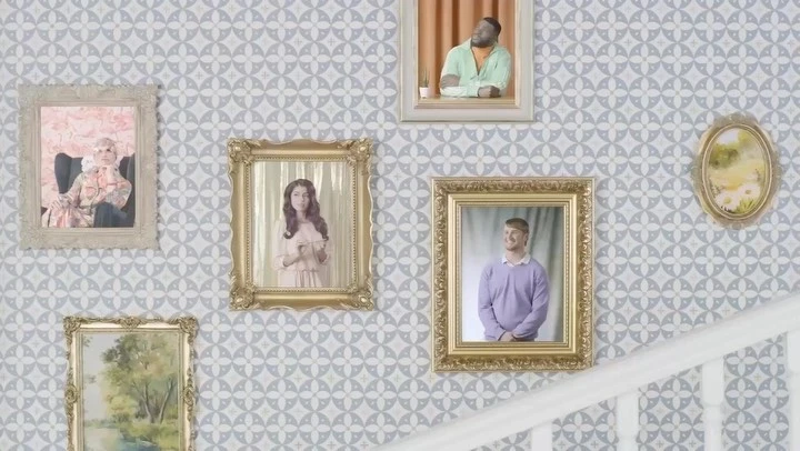 Group of portraits in ornate frames hanging on patterned wall with staircase, showcasing diverse individuals in formal settings and attire.