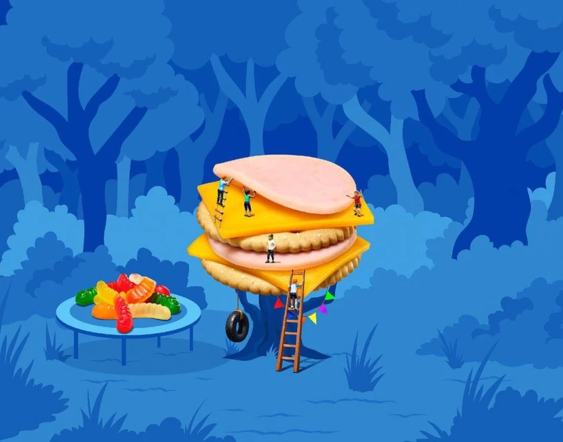 Whimsical food art of a cracker sandwich with cheese and bologna surrounded by tiny people and gummy worms in a blue forest.