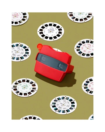A red View-Master viewer surrounded by multiple circular picture reels on a flat green background.