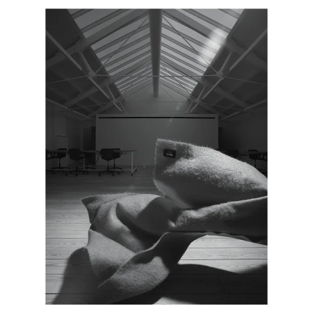 Interior view of a bright, modern conference room with natural light streaming through the windows and a soft blanket in the foreground.
