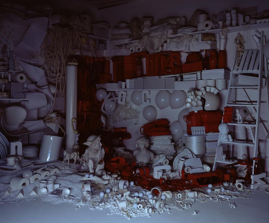 An assortment of primarily white objects arranged in an indoor setting, with red accents distributed amongst the items on shelves and the floor.