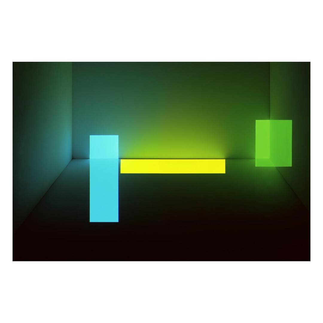 Abstract interior with blue, yellow, and green geometric shapes against a dark background, showcasing modern design and vibrant colors.