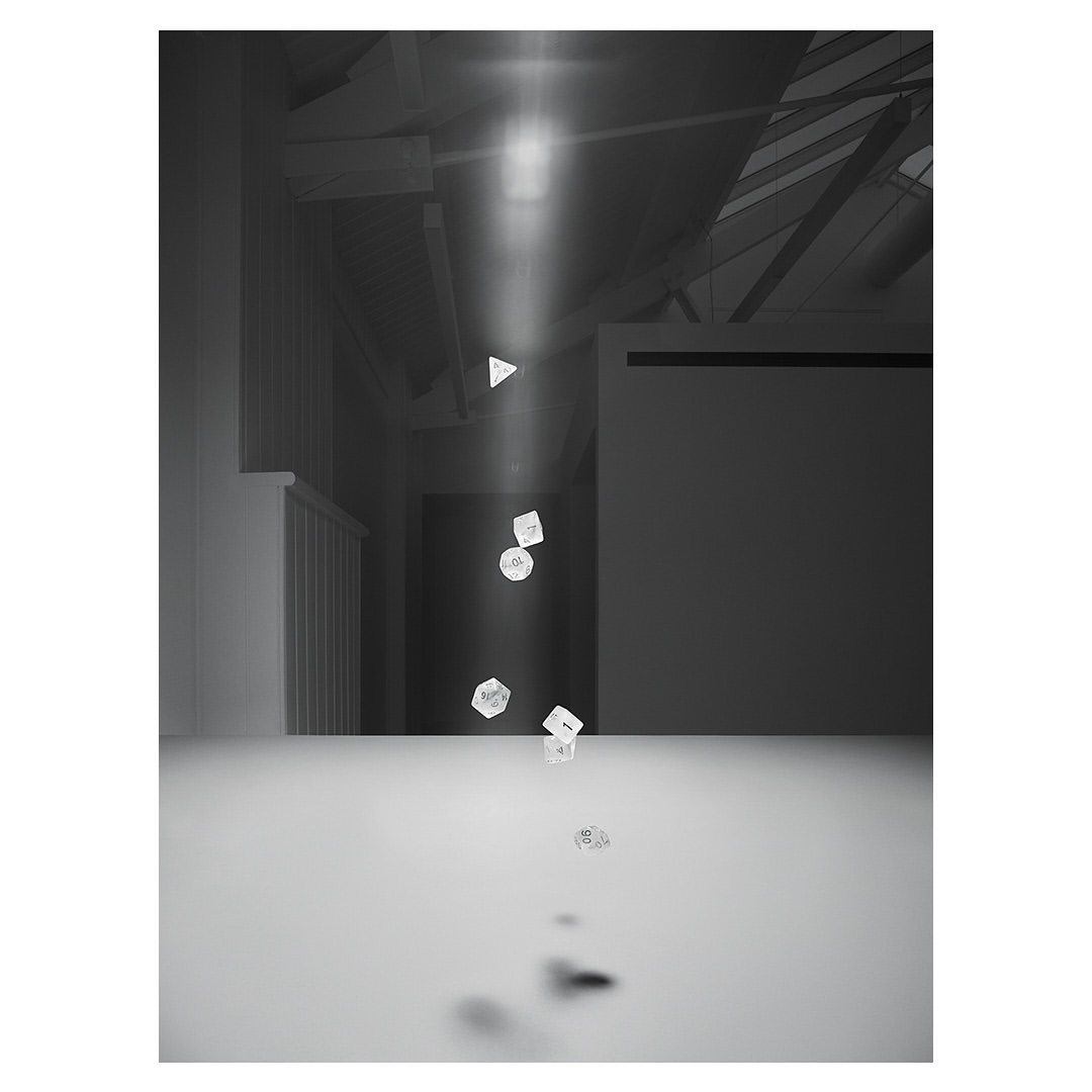 Monochromatic architectural photo of floating geometric objects illuminated by bright light, casting shadows on a white surface and walls.