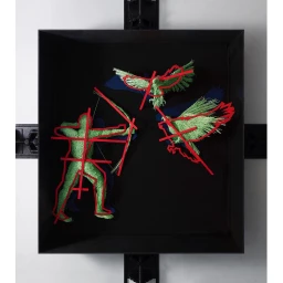 Sculptural artwork featuring a green textured archer and two birds in a dark box with red geometric lines by Dan Tobin Smith.