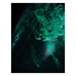 Close-up macro photography of raw emerald crystal with glowing green facets and dark shadows by Dan Tobin Smith.