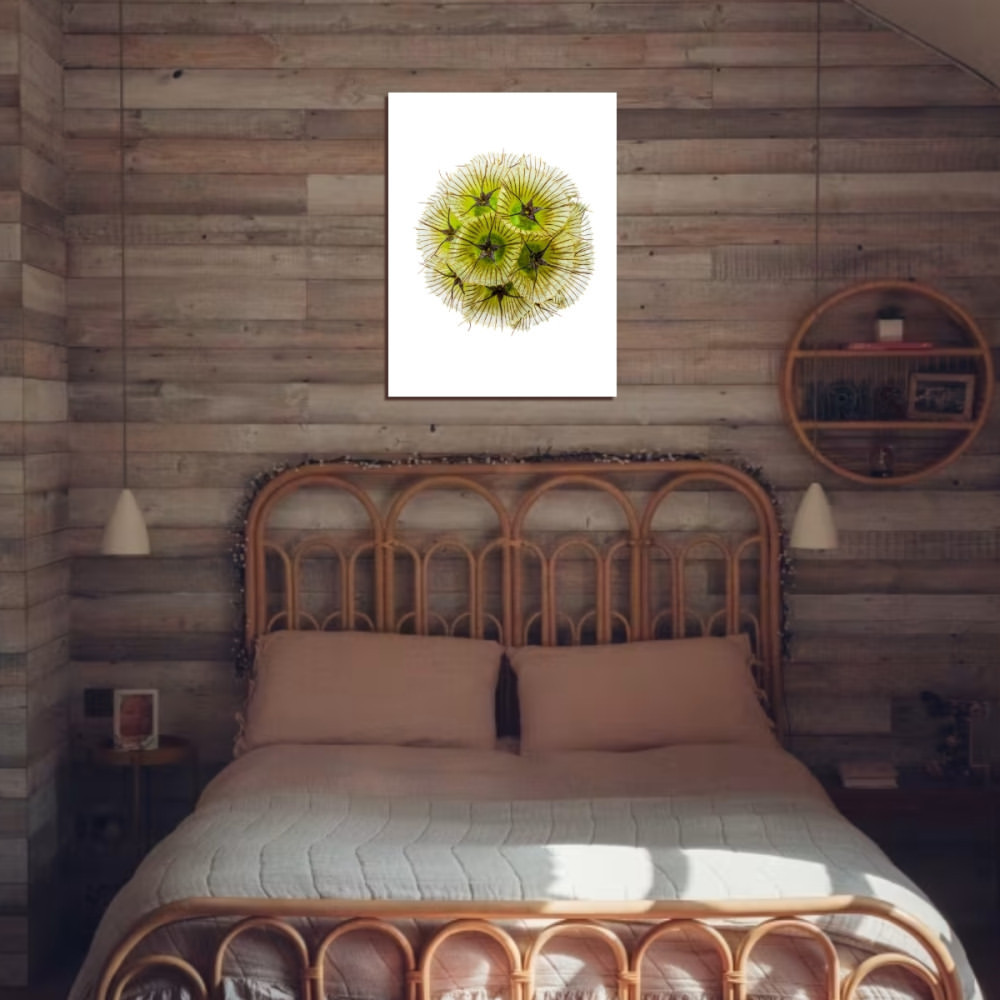 Bedroom interior featuring a bed with a rattan frame, a print of a green dahlia, and a wooden plank wall.