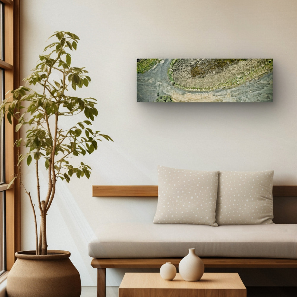 Interior design with a green potted plant near a window and a nature art print above the sofa, creating a calming aesthetic.