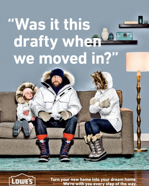 Family wearing winter coats and boots sitting on a couch, with a lamp and shelves in the background. Lowe's logo visible in the foreground.
