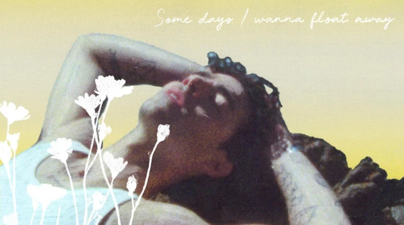 Person laying in the sun with flowers, relaxed and dreamy. Bright yellow light, natural with artistic post-production. 