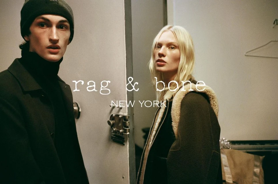 Fashion models pose in a photo studio for a Rag & Bone New York campaign, showcasing winter outerwear and minimalist style in a moody setting.