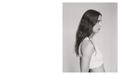 Profile portrait of a woman wearing a white tank top against a neutral studio background by Daniel Feistenauer