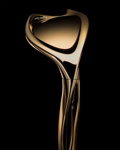 Elegant gold sculpture with smooth, curving lines against a dark background, showcasing a modern and abstract design aesthetic.