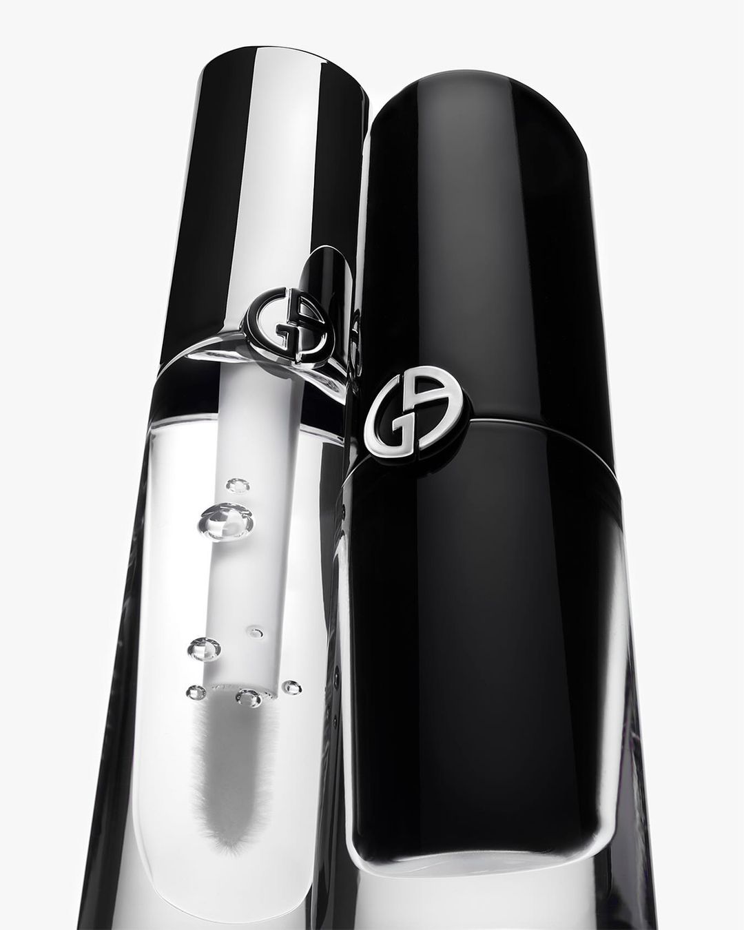 Close-up of two Giorgio Armani beauty products: one black, one clear, against a white background, showcasing the elegant packaging.