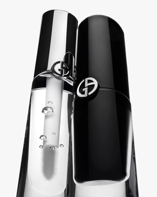 Close-up of two Giorgio Armani beauty products: one black, one clear, against a white background, showcasing the elegant packaging.