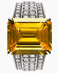 Close-up macro product shot of a large rectangular yellow gemstone ring with diamond pavé bands on white background