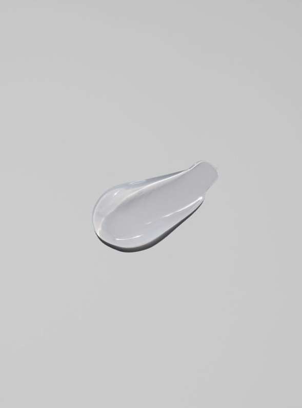 Close-up of a single swirl of moisturizer against a light gray backdrop, highlighting skincare product texture.