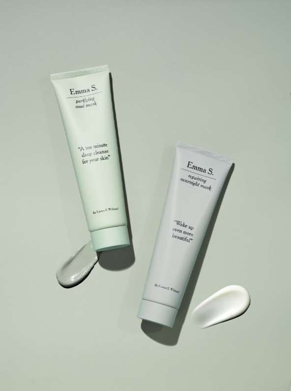 Two tubes of Emma S. skincare products with light green and white lotion, on a light green background, showcasing beauty essentials.